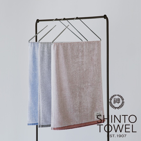 YUKINE 雪中漫步有機棉蓬厚毛巾，展示三條毛巾，分別為淺藍色、淺灰色和粉紅色，皆掛於金屬毛巾架上。