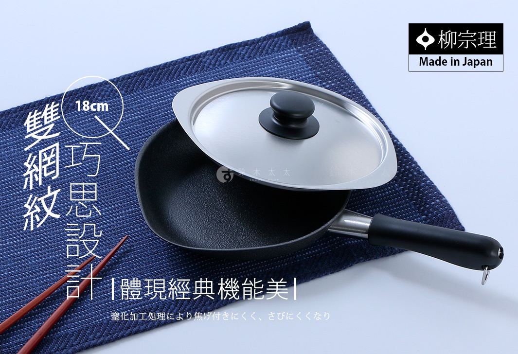 柳宗理18公分雙網紋單手鐵鍋，深色鍋體表面呈現細緻網紋，搭配不鏽鋼材質鍋蓋與黑色手柄，放置於深藍色餐墊上，整體設計呈現日式極簡風格，下方文字說明強調其透過窒化加工處理，不易焦底且防鏽。