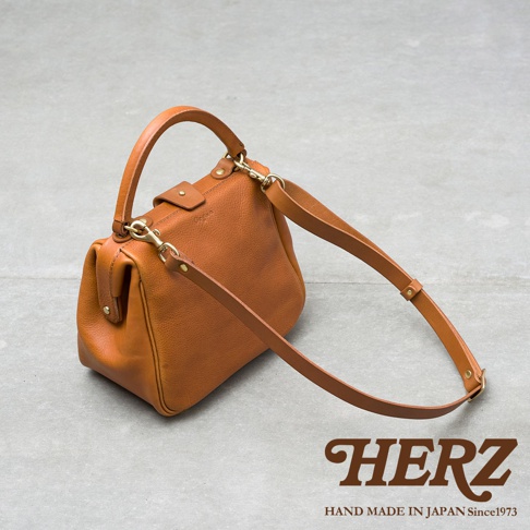 職人手作皮革Organ兩用方形口金托特包，採用天然皮革材質，呈現溫潤的棕褐色，包款設計簡潔，配有可拆卸的皮革背帶，可肩背或手提，展現經典的方形口金造型。