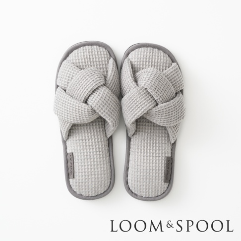 一雙交叉編織紋的灰色室內拖鞋，底部帶有LOOM&SPOOL品牌標誌