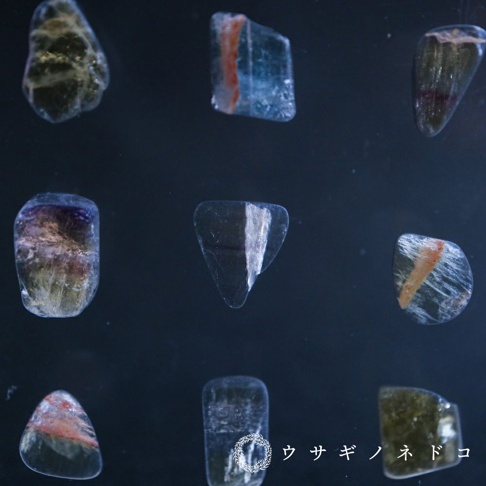 九塊大小不一、形狀各異的螢石切片標本，色彩包含透明、藍色、紫色、綠色、粉紅色及橘紅色，部分標本帶有明顯的紋理和夾層。