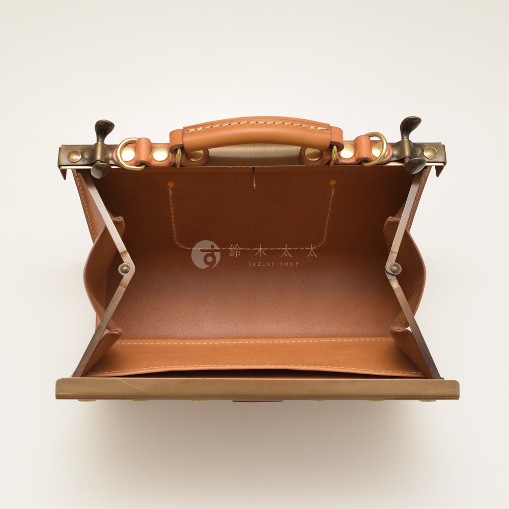 職人手作皮革復古口金兩用手提包，展示打開的狀態，露出淺棕色皮革內裡，包包帶有金屬鎖扣及手提把。