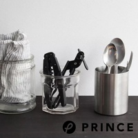 玻璃罐中裝有一條白色與黑色條紋的布巾，旁邊的透明玻璃罐內有黑色旋轉開罐器，右側則有一個銀色金屬罐，裡面插著湯匙和叉子。