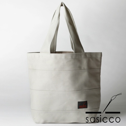 淺灰色三河木綿刺子織大容量托特包，配有兩條提把，側面有品牌標誌。