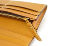 淺棕色皮革長夾，特寫拉鍊細節與內部卡槽。