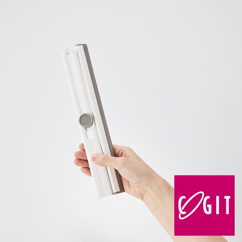 手持一個白色和灰色組合的刮水刷，刮水刷設計成可折疊且帶有旋轉鈕，主要由塑膠製成，背景為純白色。