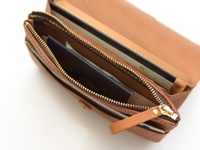 職人手作皮革長夾，淺棕色，拉鍊開闔，內有護照、機票、卡片等收納夾層，金色拉鍊與五金配件。