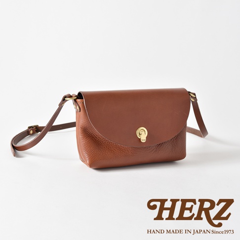 棕色皮革迷你單肩手袋，帶有可調節肩帶和金色金屬旋鎖。