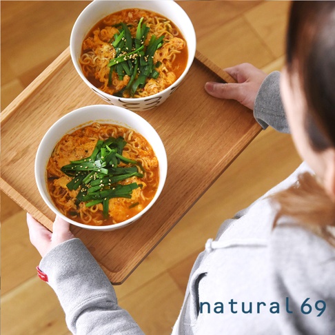 兩碗手繪丼碗，盛裝著熱騰騰的拉麵，碗內有蛋花、蔥花及芝麻，碗身為白色，外圍有黑色簡約圖案。