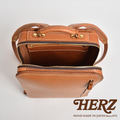 職人手作皮革商務電腦後背包 R-25，採用棕色皮革材質，頂部開口，內部結構清晰可見，配有拉鍊開合及簡約縫線裝飾。