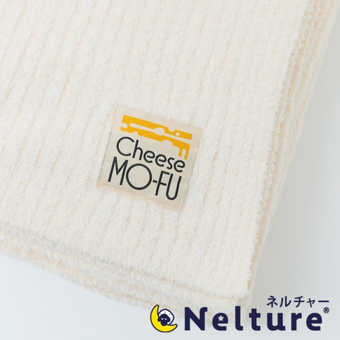 米白色柔暖毛毯，表面有細緻的條紋紋理，左上方縫有「Cheese MO-FU」字樣的淺褐色品牌標籤，標籤上有起司圖案。右下方為「Nelture」品牌標誌。