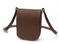 職人手作皮革翻蓋直式單肩包，採用深棕色光滑皮革製成，配有可調節的深棕色皮革肩帶和金色金屬釦環，整體設計簡約，邊緣有縫線裝飾。