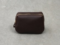 職人手作深棕色皮革拉鍊收納包，配有金色拉鍊和皮革拉頭，包身呈方形，材質柔軟，紋理清晰。