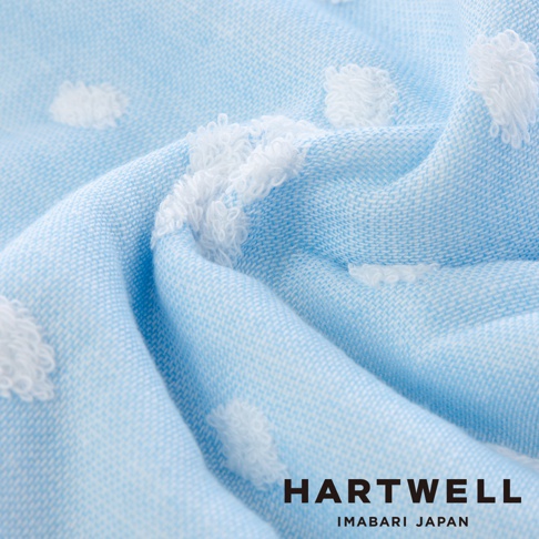 淺藍色今治純棉點點紗布毛巾，表面有白色蓬鬆的點狀織紋，材質柔軟，呈現自然的褶皺。