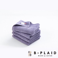 疊放的紫色薄手鱗紋毛巾，質感柔軟，帶有品牌標籤。