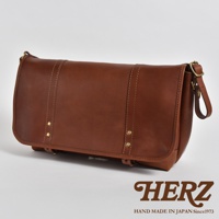 職人手作皮革復古郵差包，呈現深棕色調，以精緻縫線和金屬鉚釘裝飾，風格經典，適合日常攜帶。