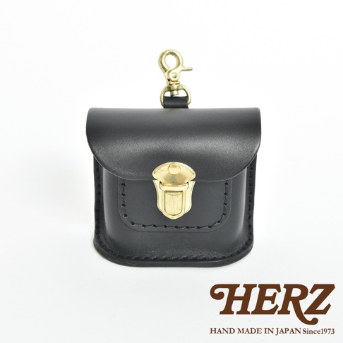 黑色皮革耳機收納包，帶有金色金屬鎖扣和掛鉤，包身有縫線裝飾。