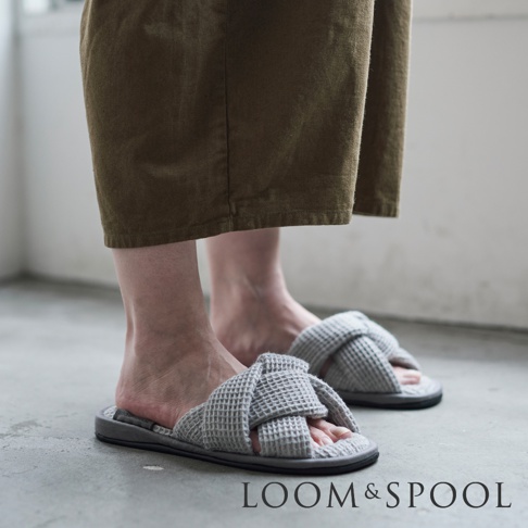腳穿著灰色交叉編織鬆餅紋室內拖鞋，搭配卡其色褲子。