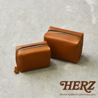 兩個棕色皮革製的箱型收納包，一個較大，一個較小，側邊拉鍊設計，右下角有HERZ品牌標誌