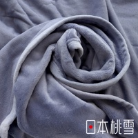 舒眠雙面四季毯，深灰色絨毛材質，觸感柔軟，對比另一面較為平滑的布料，呈現層疊的捲曲狀，展現雙面設計的質感。