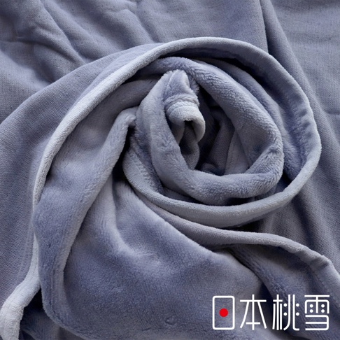 舒眠雙面四季毯，深灰色絨毛材質，觸感柔軟，對比另一面較為平滑的布料，呈現層疊的捲曲狀，展現雙面設計的質感。