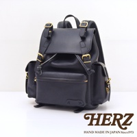 黑色皮革復古風旅行後背包，配有金色金屬扣和拉鍊，側面有兩個小口袋，正面有一個拉鍊口袋。