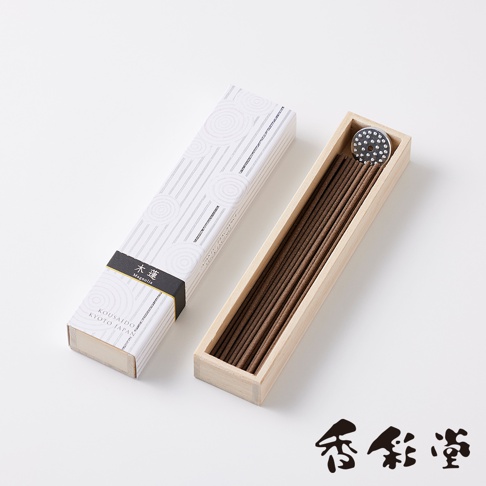一盒印有白色線條與圓形圖案的紙盒，內裝有約八種不同香氛線香，線香呈深棕色，置於木質淺盒中，盒蓋上附有黑色飾帶，印有「木蓮」與「Magnolia」字樣。