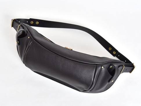 黑色皮革職人手作斜背包，配有金色拉鍊和黃銅铆釘，黑色皮革背帶可調節長度。