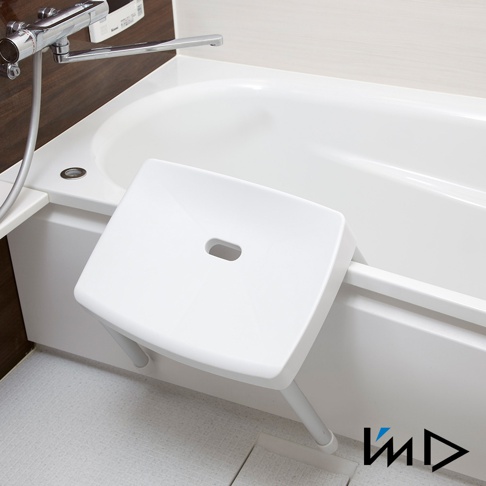 白色RETTO沐浴專用安全椅凳，椅面上有長方形孔洞，椅腳為金屬材質，固定於白色浴缸邊緣，下方為淺灰色地磚。