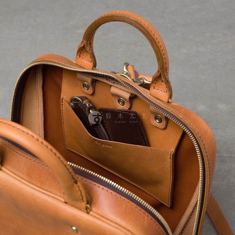 職人手作皮革Organ商務後背包 M-10的內部，可見錢包與鑰匙圈收納於內袋中