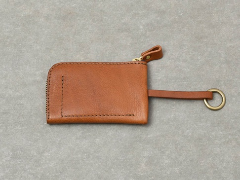 淺棕色皮革製作的職人手作Organ抽繩收納鑰匙包，配有金色拉鍊和鑰匙圈。
