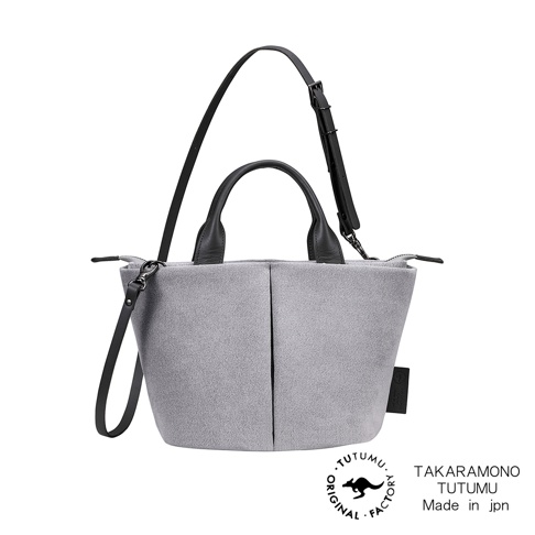 TAKＡRAMONO TUTUMU 品牌 Suede Marche petit 灰色絨面皮革兩用單肩包，配有黑色手柄和肩帶，側面有縫線設計，底部右側有黑色品牌標籤，下方為品牌標誌和產地標示。