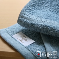 淺藍色居家浴巾，觸感柔軟，材質為純棉，帶有細緻的織紋和品牌標籤。