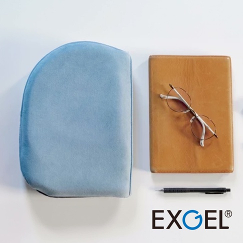 淺藍色天鵝絨材質貓頭鷹造型進階款隨身坐墊，旁邊有一個棕色皮質筆記本和一副銀框眼鏡，下方為黑色原子筆和EXGEL品牌標誌。