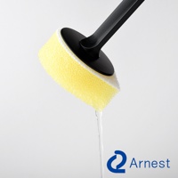 Arnest 品牌直角鍋專用清潔海綿，黃色海綿與白色部分組成，黑色手柄，海綿上有水滴下。