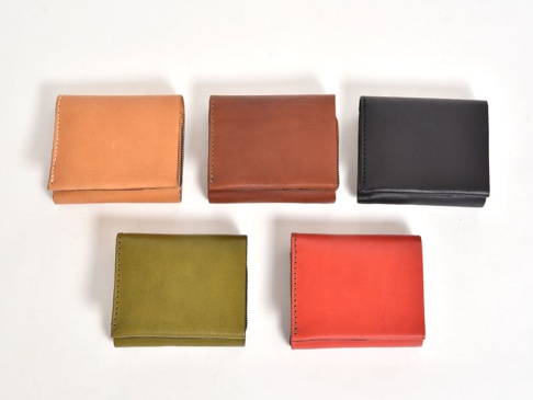五個職人手作皮革直式卡片收納雙折短夾，顏色分別為淺棕、棕色、黑色、橄欖綠及紅色，皆為對折設計，並帶有拉鍊。