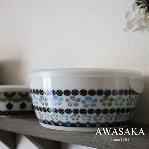 白色陶瓷保鮮碗，碗身飾有藍色、灰色花朵與黑色圓點圖案，搭配白色透明蓋子。