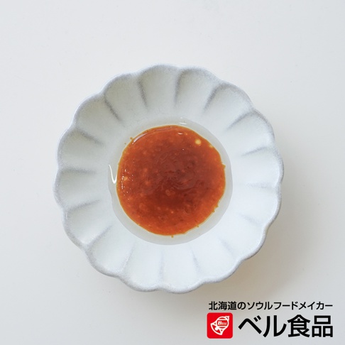 Bellfoods 北海道北見山葵風味調味醬，裝在白色花瓣狀的小碟中，醬料呈現紅褐色。