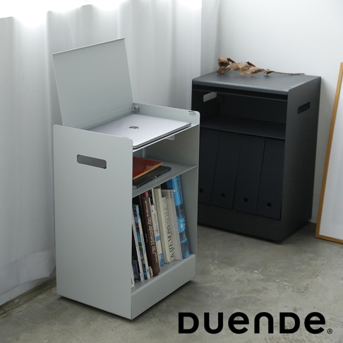 一個淺灰色的收納推車，頂部放置著一台筆記型電腦，中間層有書籍，下方層架也擺放著雜誌和書籍，推車側面有把手，後方有一個黑色的收納櫃，右下角有DUENDE的品牌標誌。