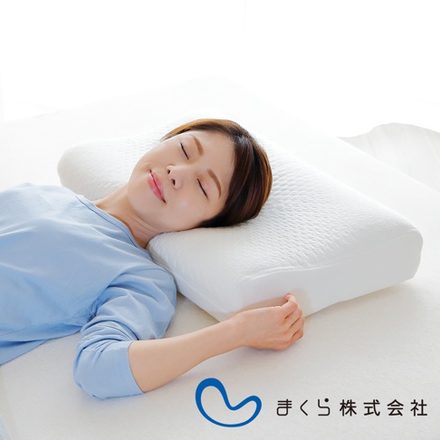 一位女士正側臥於白色透氣釋壓枕上，枕頭為白色，表面有細小紋路，中間有凹槽以支撐頸部。