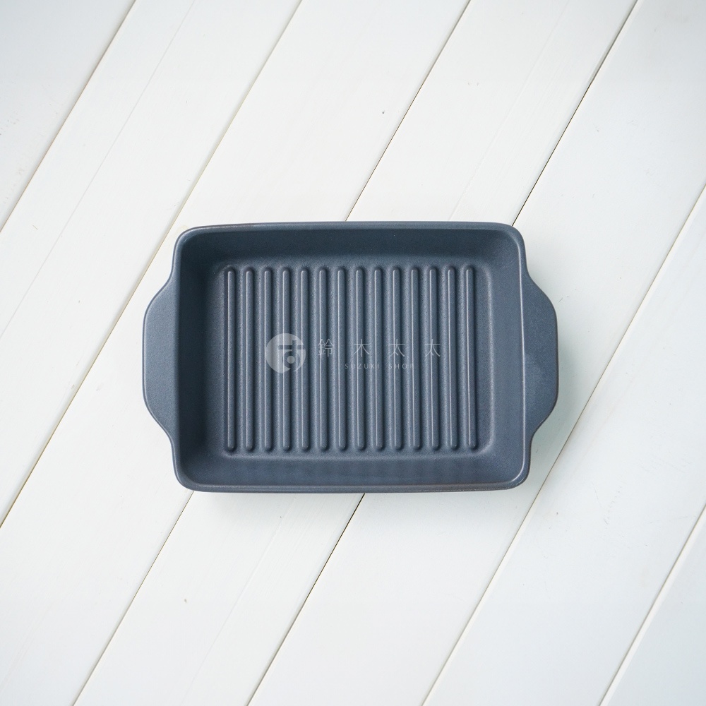 深灰色陶製長方形烤盤，內部設有波浪紋路，兩側有提把，整體呈現簡約設計。