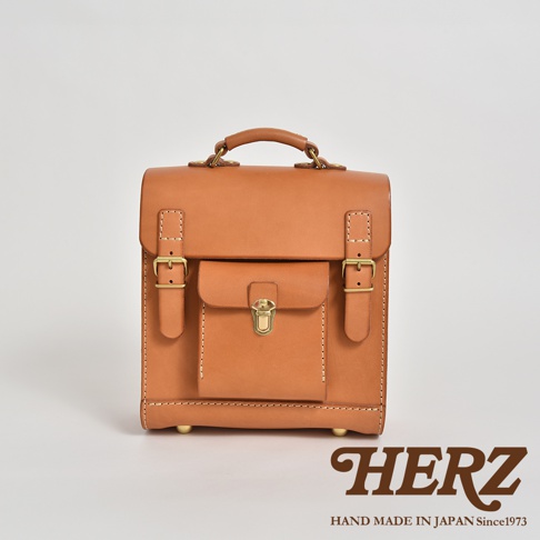 棕色皮革迷你後背包，學院風設計，配有金色金屬扣環和磁扣，手工縫線，頂部提把，四個金屬腳釘。