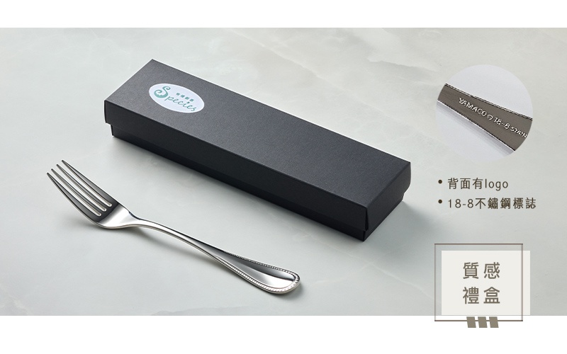 一個不鏽鋼叉放在一個黑色禮盒旁，叉子手柄上有精緻的紋飾，放大圖顯示叉子背面有YAMACO 18-8 STAINLESS字樣。