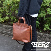 職人手作皮革大容量兩用托特包，採用棕色皮革製成，具備手提帶和可拆卸肩帶，設計簡潔實用。