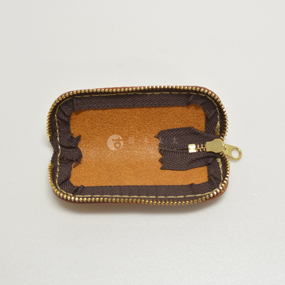職人手作皮革印章收納袋，棕色皮革內裡，搭配深棕色布質外層及金色拉鍊。