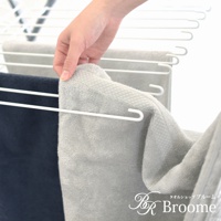 一隻手拿起一條淺灰色的今治純棉浴巾，浴巾表面有菱紋織法，材質柔軟。旁邊還有一條深藍色的浴巾。