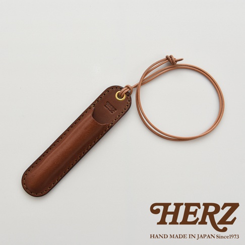 職人手作皮革掛繩筆套，附有品牌標誌，質感棕色皮革，設計簡約。