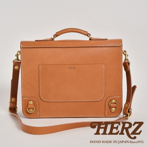 職人手作極簡風三用商務公事包，採用棕褐色皮革製作，帶有經典的縫線細節，正面設有翻蓋式口袋，配有手提把和可拆卸肩帶，風格簡約實用。