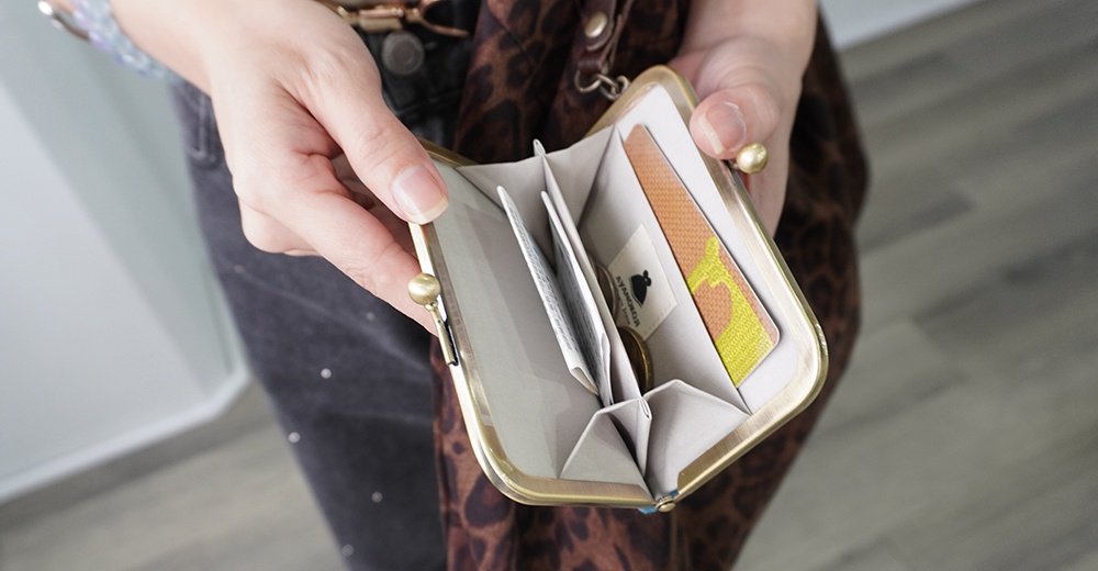 綾小路帆布橫式口金卡片收納包，內有卡片和一枚硬幣。