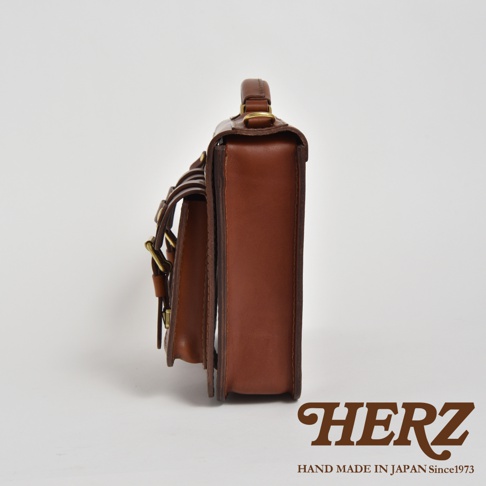 職人手作皮革雙口袋兩用單肩包 A-19，側邊視角，展示棕色皮革材質、雙前袋設計及金屬扣環。